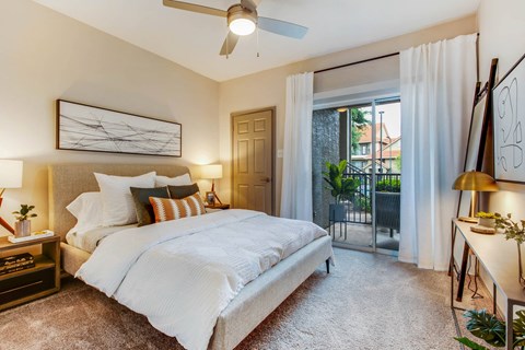 a bedroom with a bed and a door to a balcony